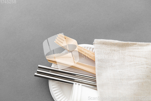 Image of wooden forks, knives and paper cups on plate