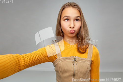 Image of funny teenage girl taking selfie and making faces