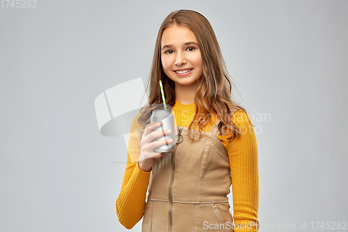 Image of happy teenage girl drinking soda from can