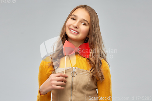 Image of happy teenage girl with red bowtie party accessory