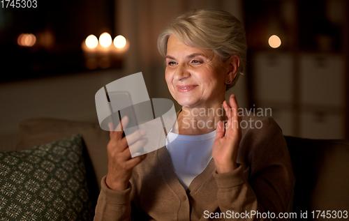 Image of happy old woman with smartphone having video call