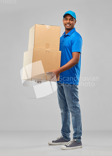 Image of happy indian delivery man with parcel boxes