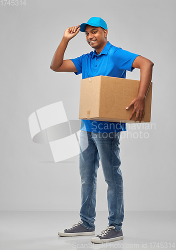 Image of happy indian delivery man with parcel box in blue