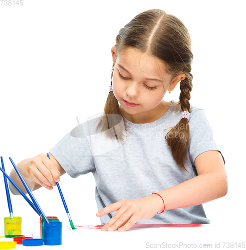 Image of Little girl is painting with gouache