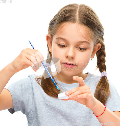 Image of Little girl is painting with gouache
