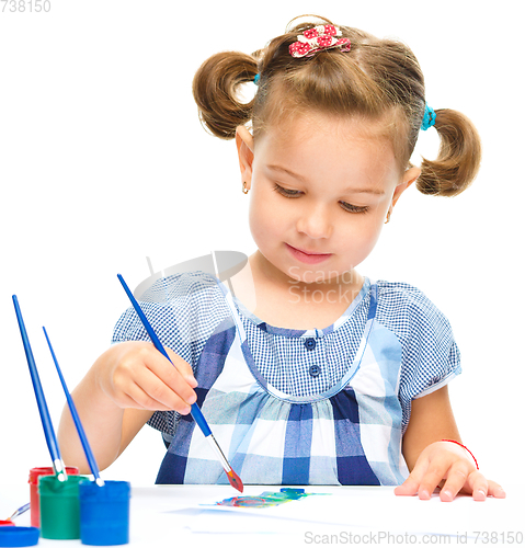 Image of Little girl is painting with gouache