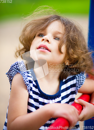 Image of Cute little girl is playing in playground