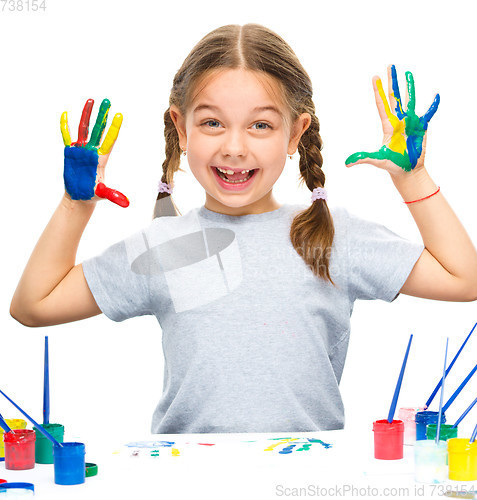 Image of Portrait of a cute girl playing with paints