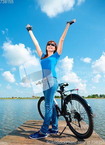 Image of Young woman raised her hands up in joy