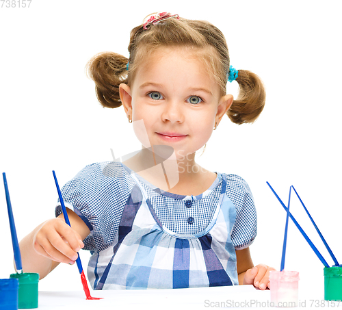 Image of Little girl is painting with gouache