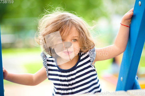 Image of Cute little girl is playing in playground