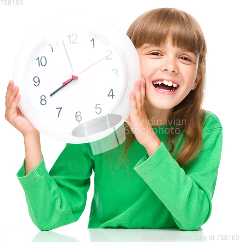 Image of Little girl is holding big clock