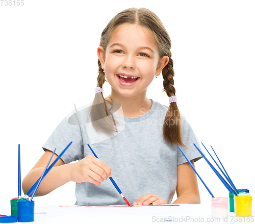 Image of Little girl is painting with gouache