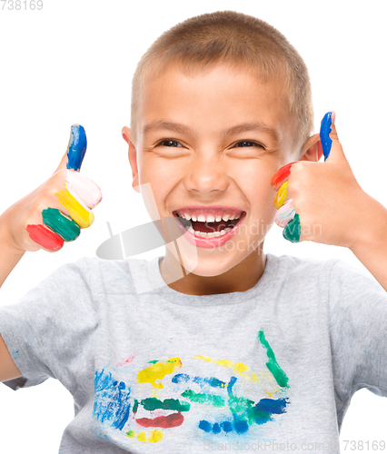 Image of Portrait of a cute boy playing with paints