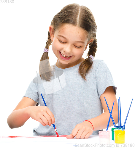 Image of Little girl is painting with gouache