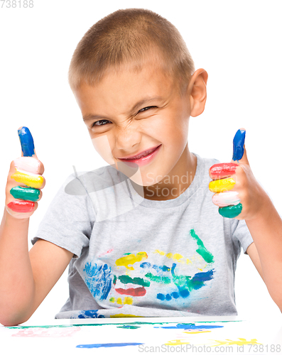 Image of Portrait of a cute boy playing with paints