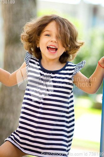 Image of Cute little girl is playing in playground