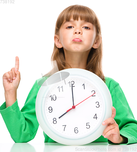 Image of Little girl is holding big clock