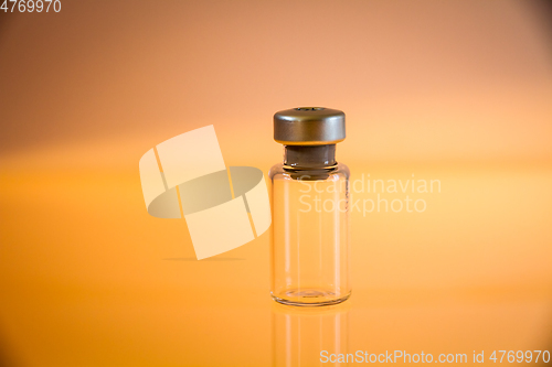 Image of Vaccine bottle on orange background