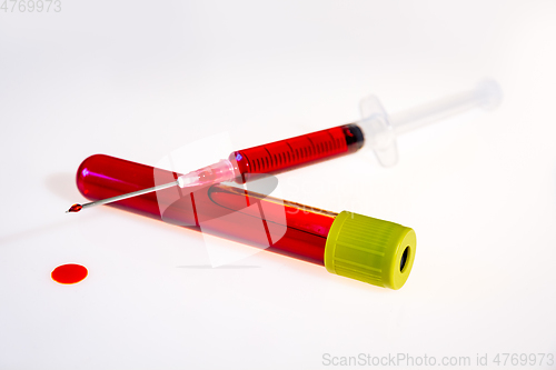 Image of Syringe and tube with blood on white background