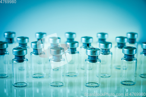 Image of Vaccine glass bottles on blue background