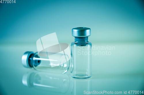 Image of two vaccine bottles on blue background