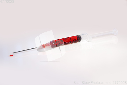 Image of Syringe with blood on white background