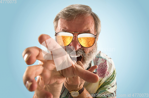 Image of Oktoberfest senior man with sunglasses full of light beer