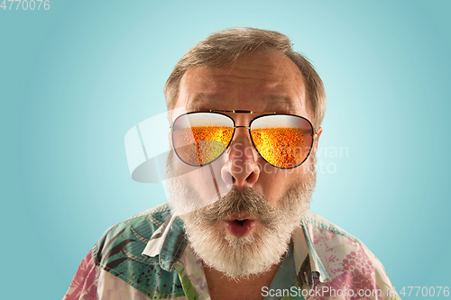 Image of Oktoberfest senior man with sunglasses full of light beer