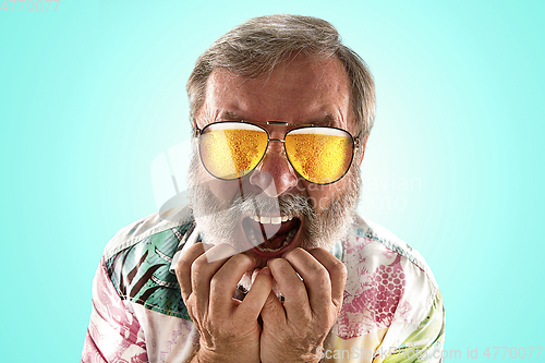 Image of Oktoberfest senior man with sunglasses full of light beer