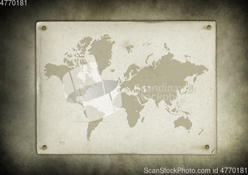 Image of Vintage world map parchment nailed to a wall