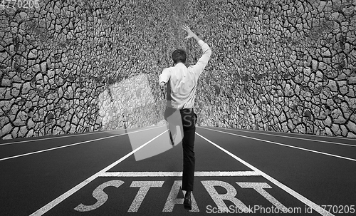 Image of Businessman jumping on a starting grid with cityscape on the background