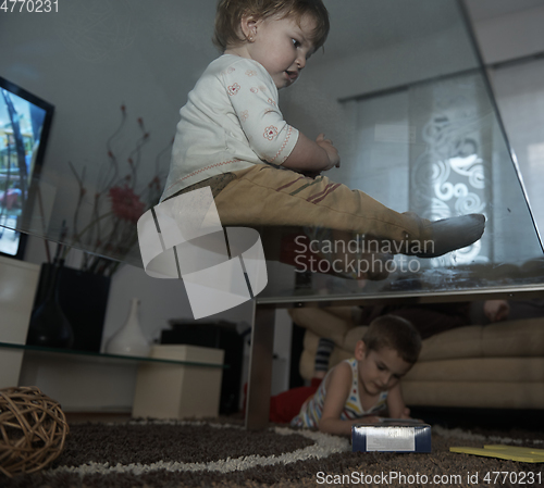 Image of Little child playing with sister at home