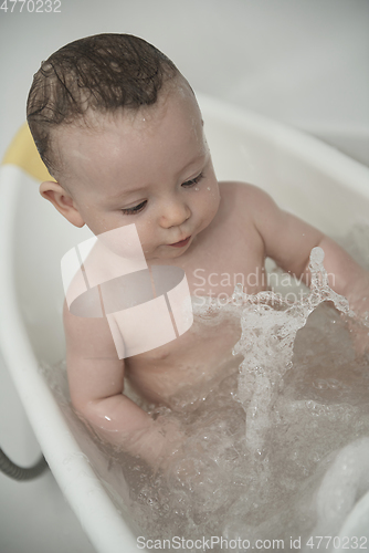 Image of cute little baby girl taking a bath