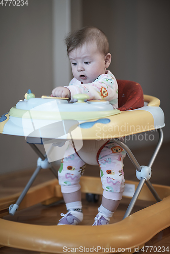 Image of baby learning to walk in walker