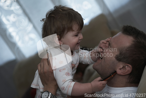 Image of father holding and kissing little baby