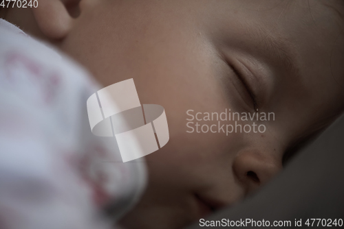 Image of newborn baby sleeping at home in bed