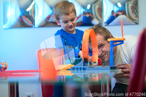 Image of Father and children playing car toy game