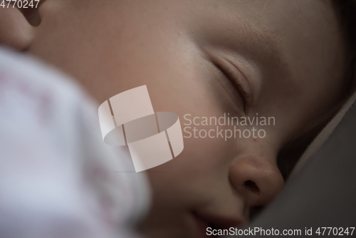 Image of newborn baby sleeping at home in bed