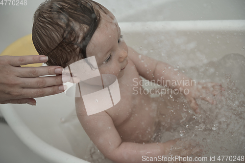 Image of cute little baby girl taking a bath