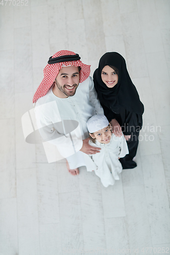 Image of Top view of young arabian muslim family wearing traditional clothes