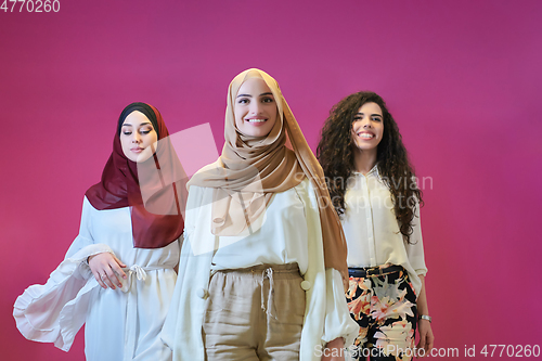 Image of Young muslim women posing on pink background