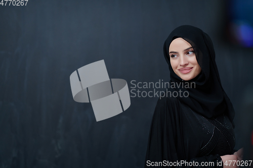 Image of Modern young muslim woman in black abaya