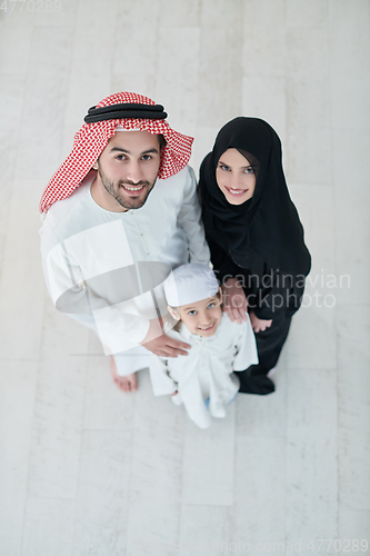 Image of Top view of young arabian muslim family wearing traditional clothes