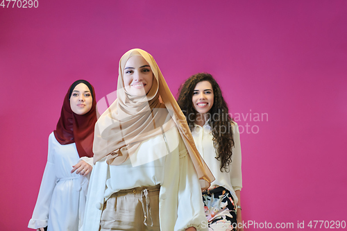 Image of Young muslim women posing on pink background