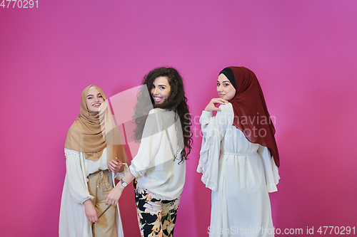 Image of Young muslim women posing on pink background