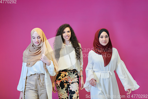 Image of Young muslim women posing on pink background