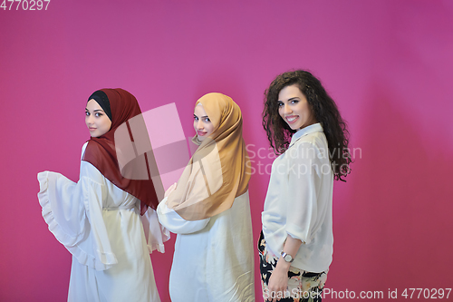 Image of Young muslim women posing on pink background