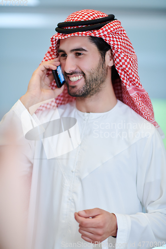 Image of Portrait of young muslim businessman using mobile phone