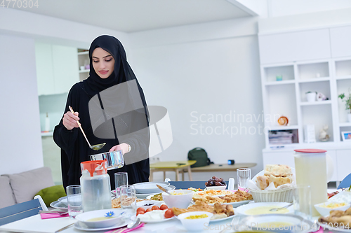 Image of Young muslim woman serving food for iftar during Ramadan